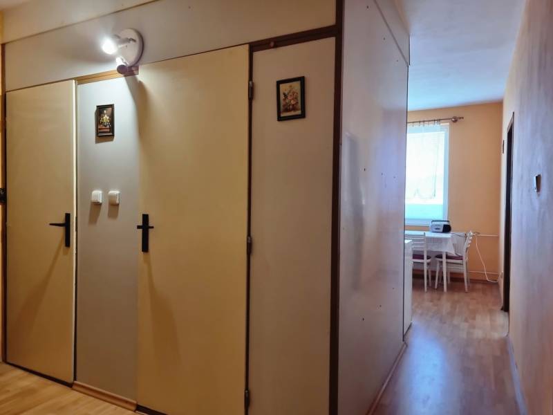Der Flur in der 2-Zimmer-Wohnung mit Einbauschränken und Blick in die Küche.