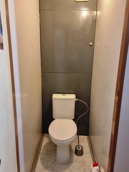 Toilette in einer 2-Zimmer-Wohnung mit weißem Marmorbodenbelag.
