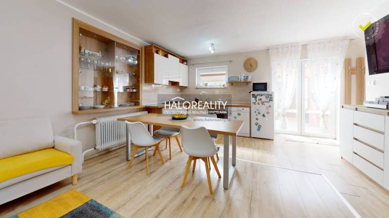 Interieur eines Einfamilienhauses mit Esstisch, Küche und Regalen für Geschirr.