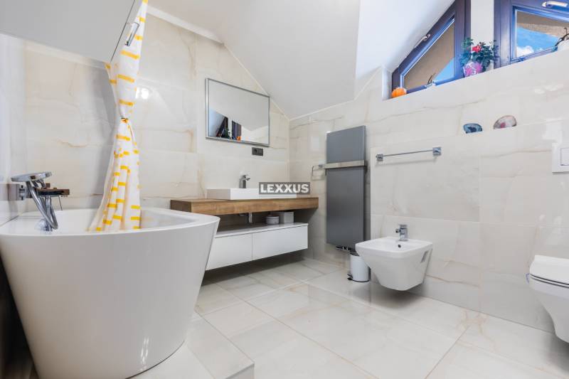 Badezimmer mit Badewanne, Waschbecken und Bidet in einem Einfamilienhaus.