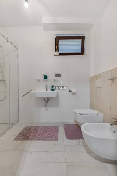 Badezimmer in einem Einfamilienhaus mit Waschbecken, Dusche, Toilette und Bidet.