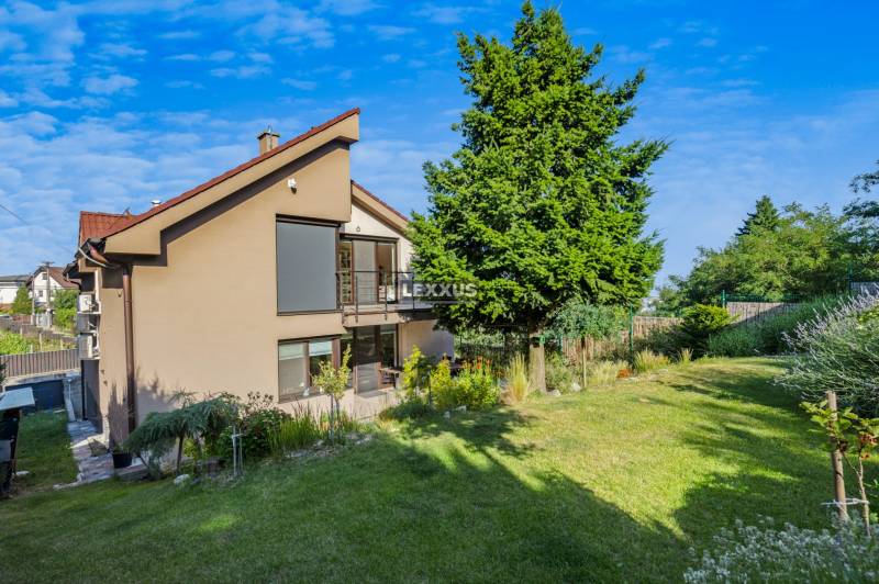 Ein Einfamilienhaus in der Zvončeková-Straße in Bratislava-Rača mit Garten und Bäumen.