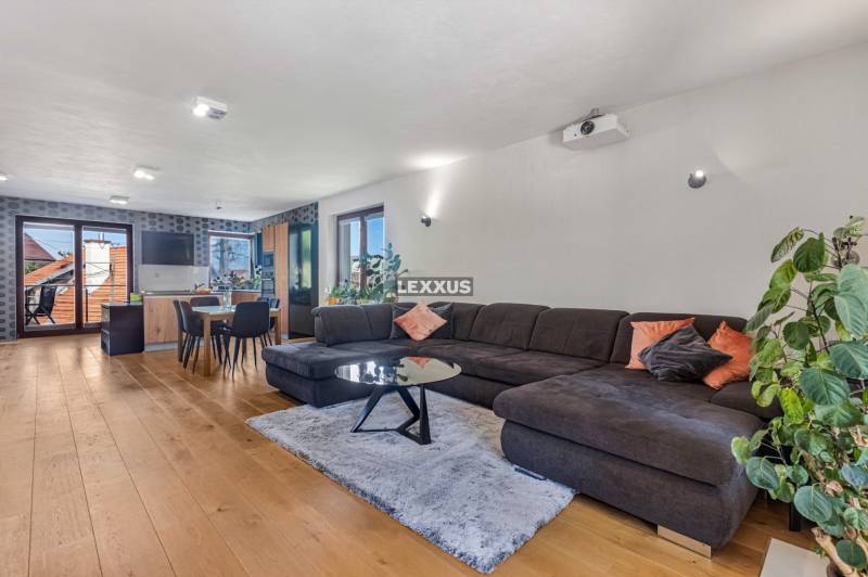 Geräumiger Wohnbereich mit Küche, Esstisch und bequemer Couch in einem Einfamilienhaus.