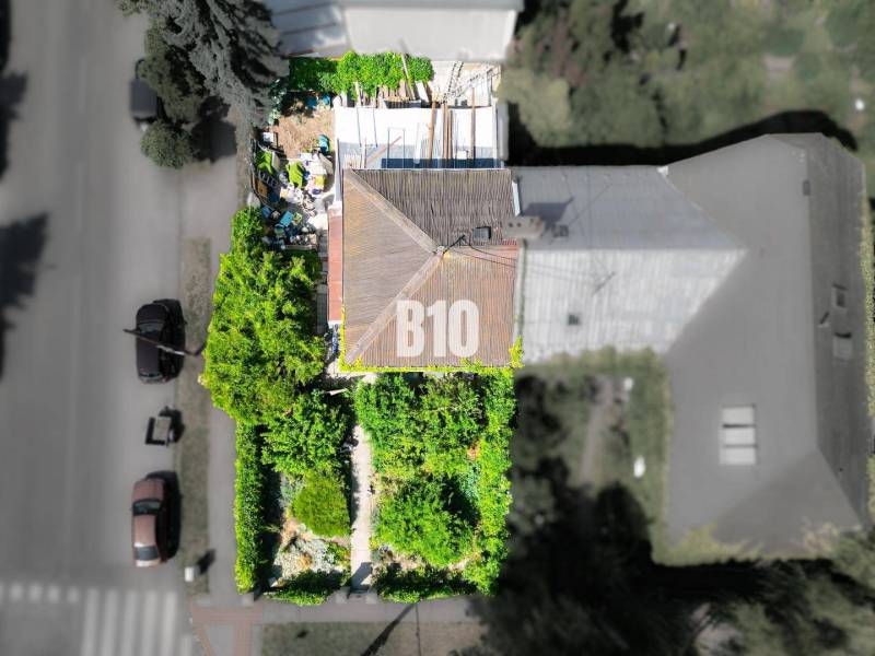 Ein Einfamilienhaus in Bratislava - Altstadt, umgeben von Grünflächen und einem Garten aus der Vogelperspektive.