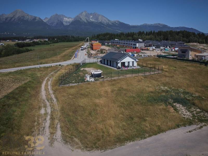 Grundstücke zum Wohnen in Mlynica mit Blick auf die Tatra, ein Landhaus und Gebäude im Hintergrund.