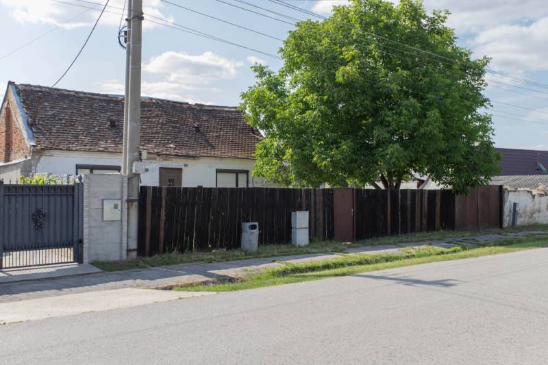 Ein Haus mit einem Holzzaun und einem Baum in der Športová-Straße in Gajary, Grundstücke - Wohnen.