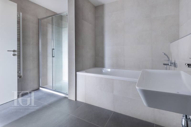 Badezimmer in einer 3-Zimmer-Wohnung mit Badewanne, Dusche und Waschbecken.