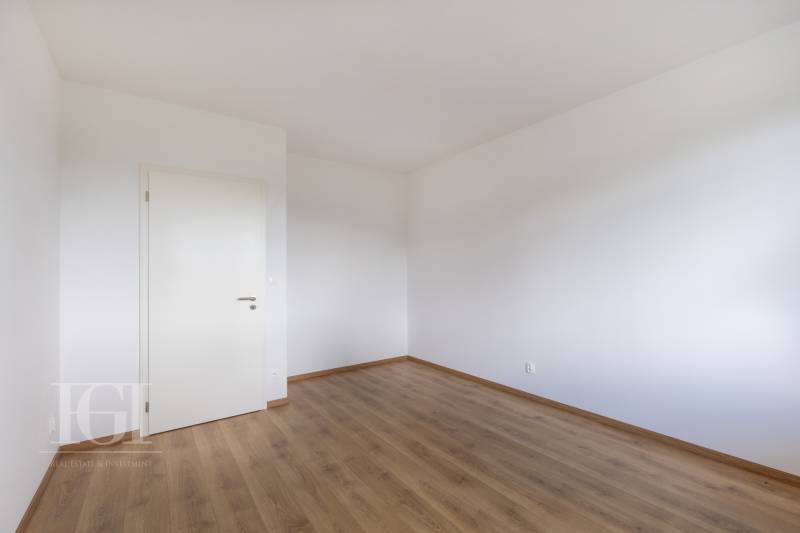 Ein leerer Raum mit weißen Wänden und Holzboden, geeignet für eine 3-Zimmer-Wohnung.