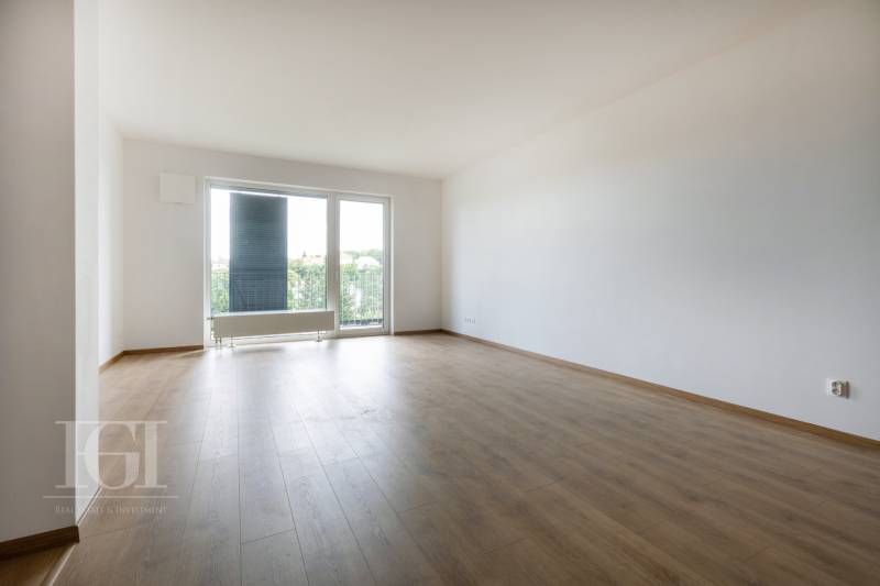 Geräumiges Wohnzimmer in einer 3-Zimmer-Wohnung mit Blick durch ein großes Fenster.