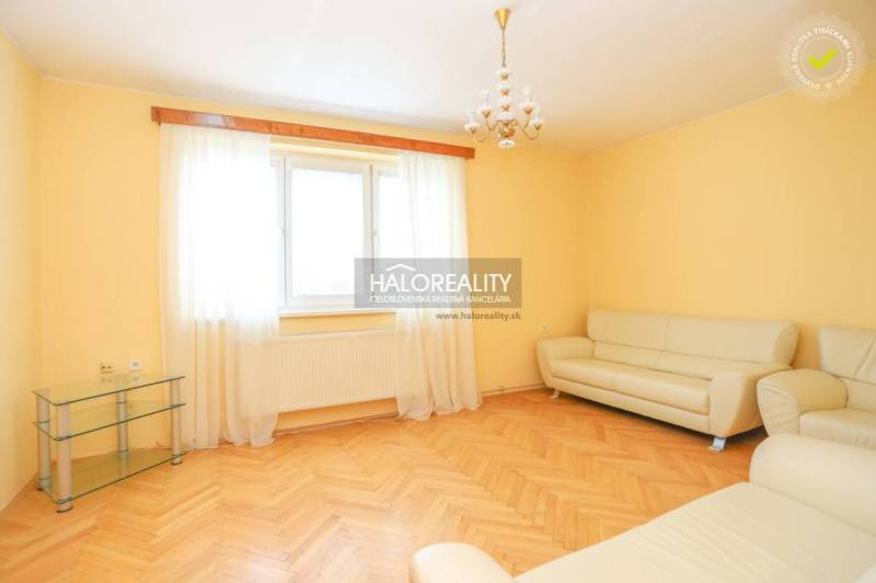 Wohnzimmer in einer 3-Zimmer-Wohnung mit einem hellen Sofa und Holzboden.