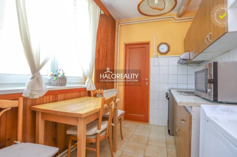 Küche in einer 3-Zimmer-Wohnung mit Holztisch und Stühlen.