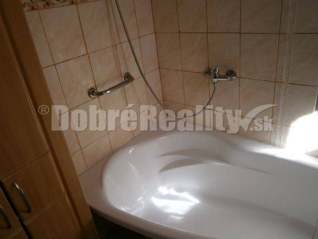 Badezimmer in einem Einfamilienhaus mit Badewanne und Duschkopf.