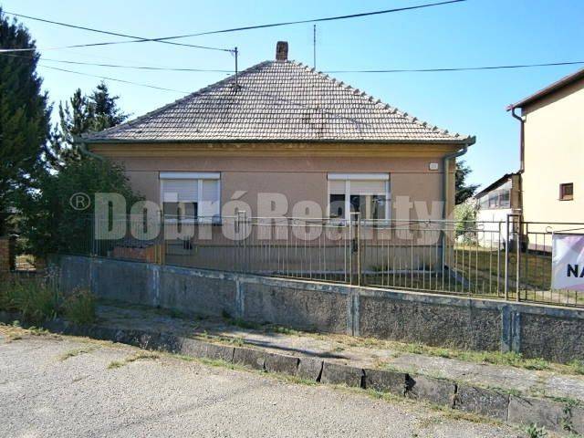 Ein Einfamilienhaus in Rúbaň mit einer einfachen Fassade, einem schrägen Dach und einem Vorgarten.