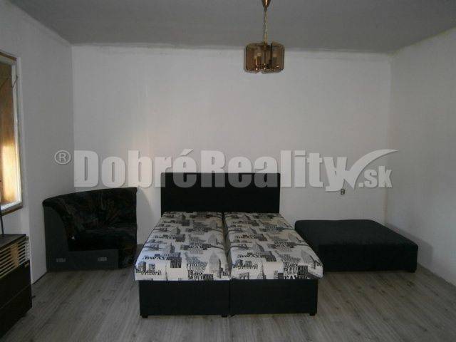 Schlafzimmer im Einfamilienhaus mit Bett, Sofa und Holzboden.