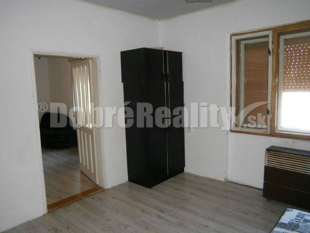 Einfaches Interieur in einem Einfamilienhaus mit Holzboden und dunklem Kleiderschrank.