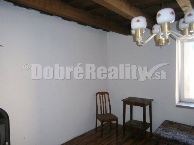 Einfach eingerichtetes Zimmer in einem Einfamilienhaus mit Holzdecke und Holzboden.