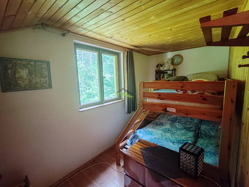 Etagenbett im Inneren einer Hütte mit Holzdecke.