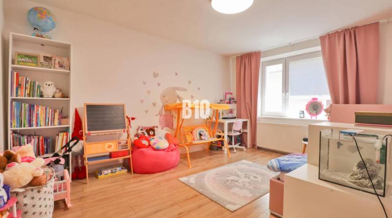 Kinderzimmer in einem Einfamilienhaus mit Spielzeug, Büchern, Tafel und Aquarium.