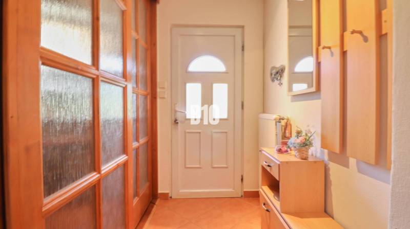 Ein Flur mit Holzmöbeln und Türen in einem Einfamilienhaus.