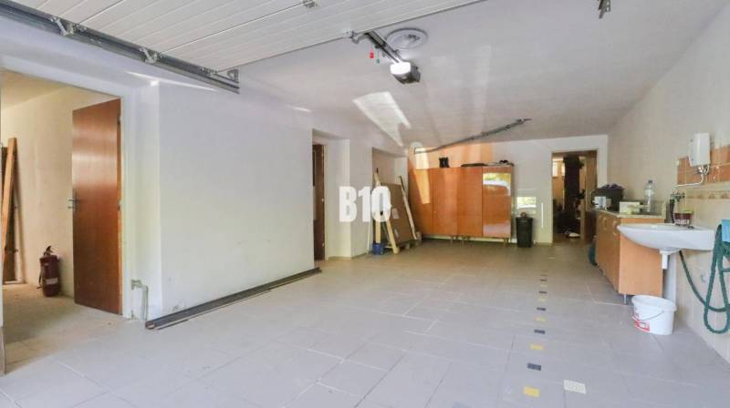 Geräumige Garage in einem Einfamilienhaus mit Waschbecken und Stauraum.