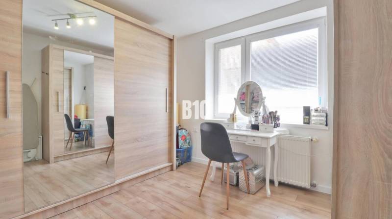 Ein Kleiderschrank und ein Schminktisch im Interieur eines Einfamilienhauses mit einem großen Spiegel und einem geräumigen Schrank.