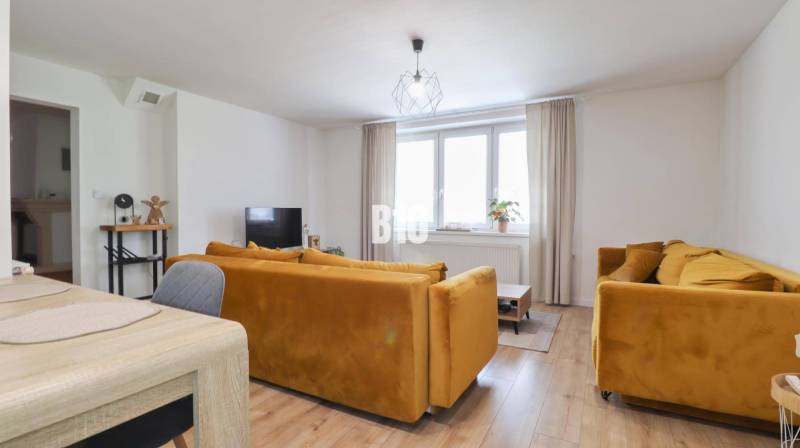 Wohnzimmer in einem Einfamilienhaus mit gelben Sofas und Esstisch.