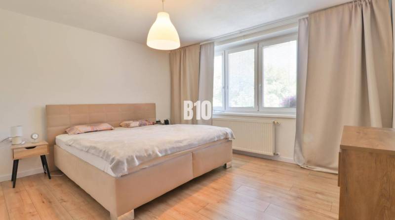 Ein Schlafzimmer in einem Einfamilienhaus mit einem großen Bett und minimalistischen Möbeln.