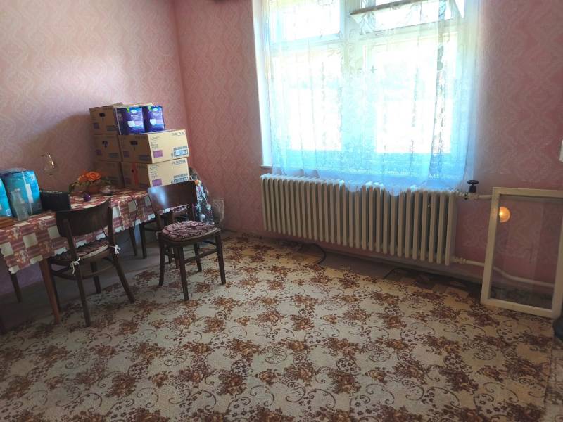 Ein Zimmer in einem Einfamilienhaus mit Teppichmuster und einem Tisch mit Stühlen.