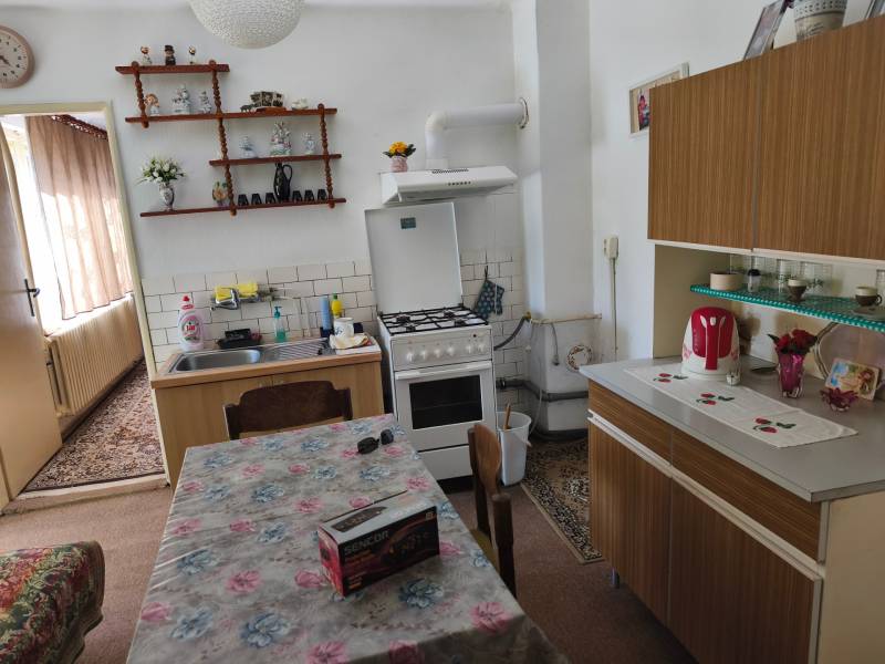 Küche in einem Einfamilienhaus mit Esstisch, Küchenzeile und Dekorationen auf dem Regal.