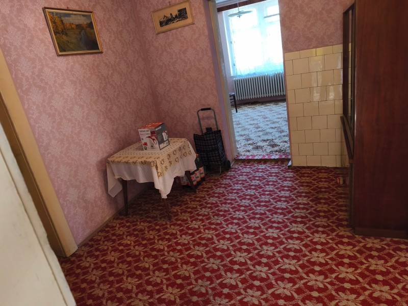 Innenraum eines Einfamilienhauses mit Teppich, Tapeten und Möbeln, einschließlich eines Bildes an der Wand.