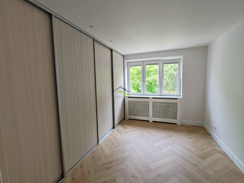 Ein Zimmer in einer 2-Zimmer-Wohnung mit Einbauschrank und Fenster, helle Parkettböden.