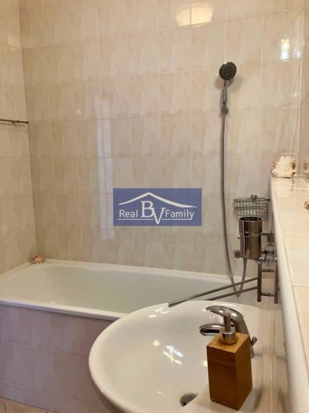 Badezimmer mit Badewanne, Waschbecken und Dusche in einer Einzimmerwohnung.