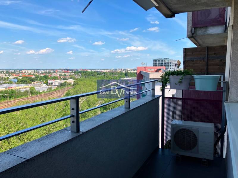 Blick vom Balkon auf die Stadtlandschaft, die Eisenbahn und das Grün von einer Einzimmerwohnung.