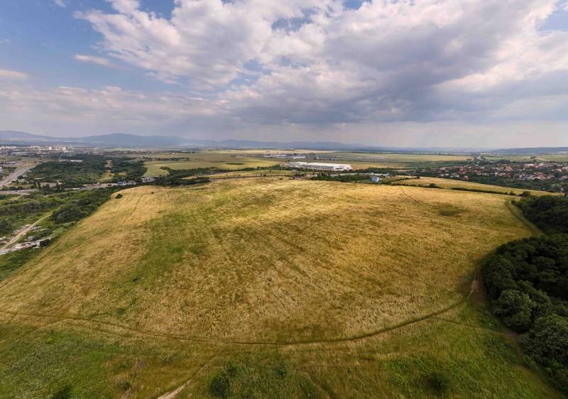 Umfangreiche landwirtschaftliche und forstwirtschaftliche Flächen in Košice, Stadtteil Luník IX, unter wolkigem Himmel.