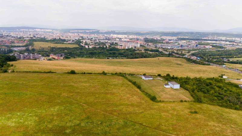 Landwirtschaftliche und forstwirtschaftliche Flächen in Košice, Stadtteil Luník IX, mit der Stadt im Hintergrund.