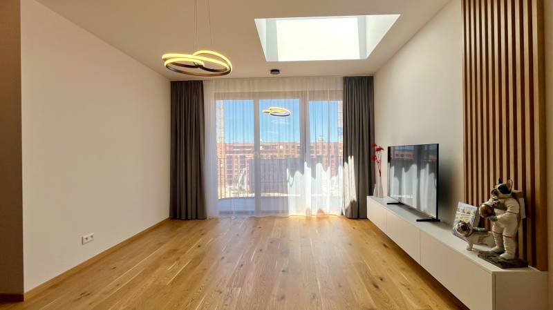 Wohnzimmer in einer Zweizimmerwohnung mit Fernseher und Dekorationen auf dem Boden.