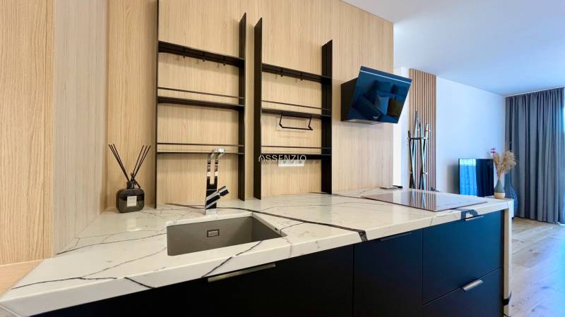 Küchenzeile mit Marmor-Arbeitsplatte und offenen Regalen in einer 2-Zimmer-Wohnung.