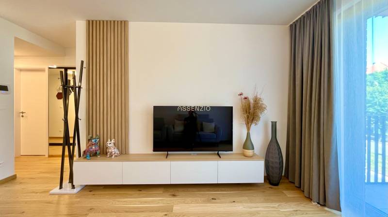 Helles Wohnzimmer in einer 2-Zimmer-Wohnung mit Fernseher und Dekorationen.