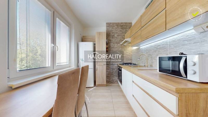 Küche in einer 3-Zimmer-Wohnung mit eingebautem Gerät, Holzschränken und Esstisch.