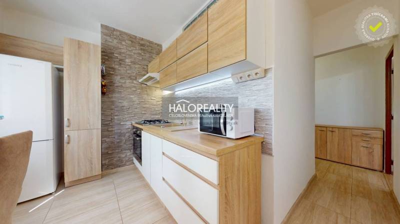 Küche in einer 3-Zimmer-Wohnung mit Holzmöbeln und Backsteinwandverkleidung, Geräte.