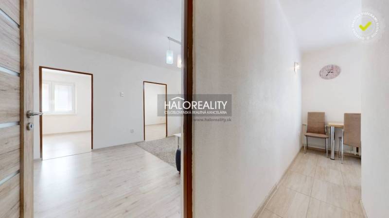 Flur mit Zugang zu den Zimmern in einer 3-Zimmer-Wohnung, Tisch und Stühle an der Wand.