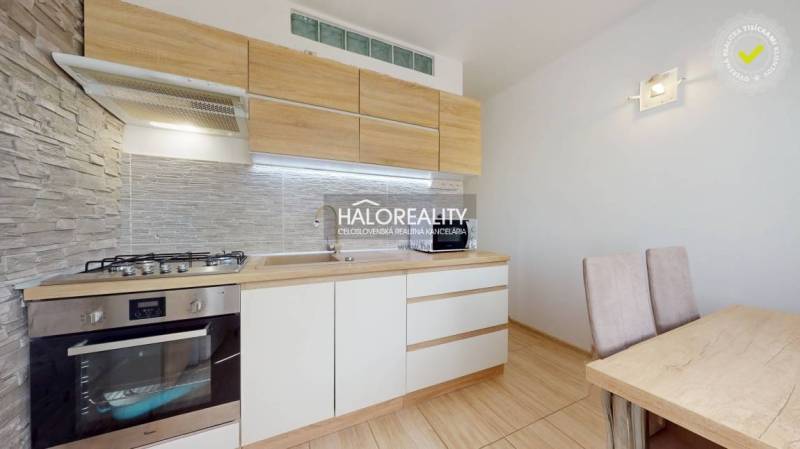 Küche in einer 3-Zimmer-Wohnung mit Holzschränken und Esstisch.