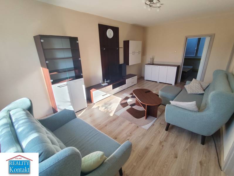 Wohnzimmer in einer 3-Zimmer-Wohnung mit Sofa, Couchtisch und Vitrine.