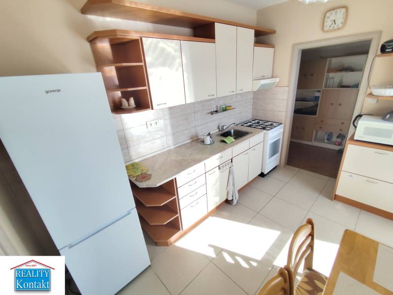 Küche einer 3-Zimmer-Wohnung mit weißen Geräten und Küchenzeile.