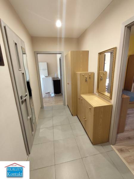 Ein Flur mit Fliesenboden und Holzmöbeln in einer 3-Zimmer-Wohnung.