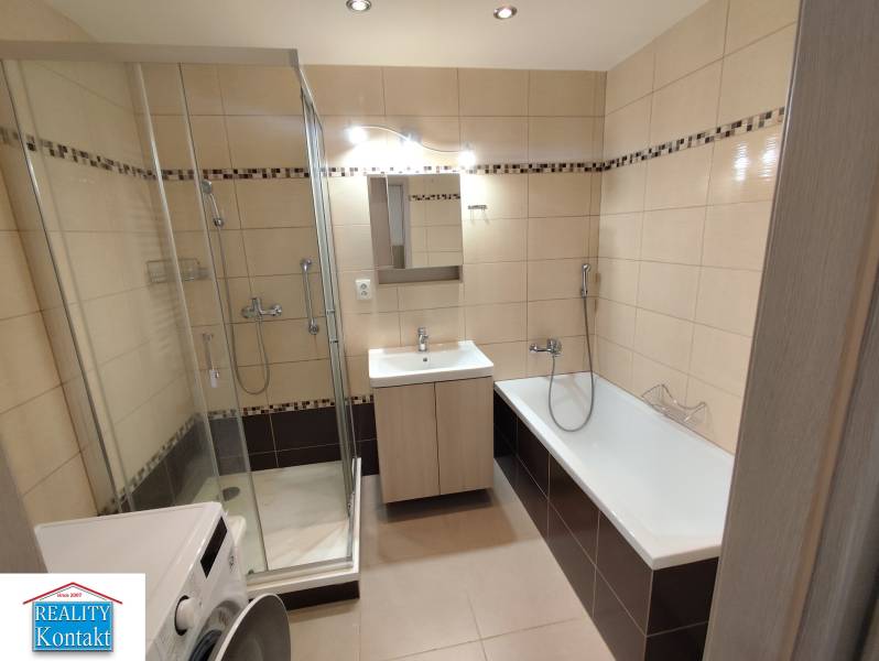 Badezimmer in einer 3-Zimmer-Wohnung mit Dusche und Badewanne, helle Fliesen.