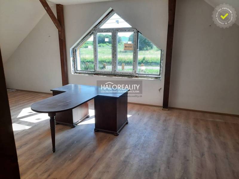 Innenraum einer 2-Zimmer-Wohnung mit Holztisch und Blick durch ein großes Fenster.