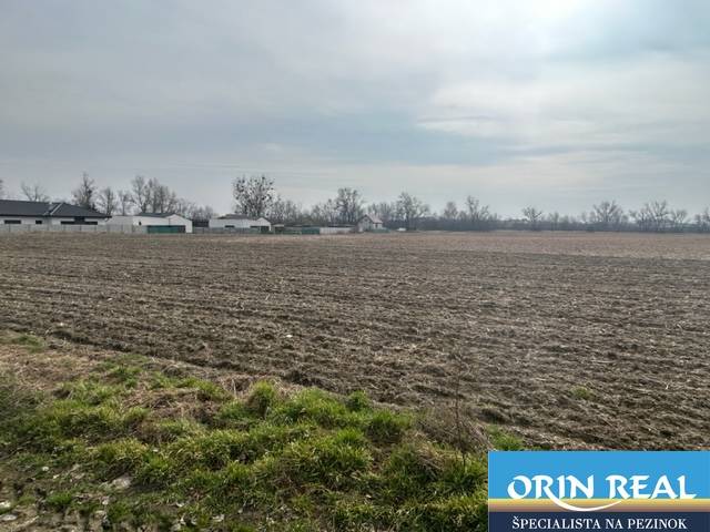 Landwirtschaftliche und forstwirtschaftliche Flächen in Domky in Zálesí mit Gebäuden im Hintergrund.