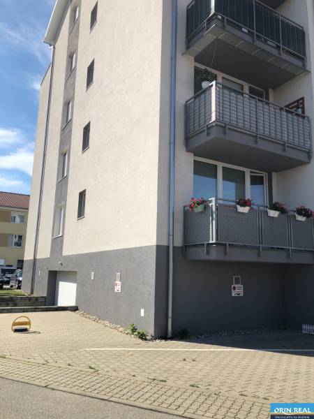 Ein vierstöckiges Gebäude mit Balkonen und einer Garage in der Rastislavova-Straße in Slovenský Grob.