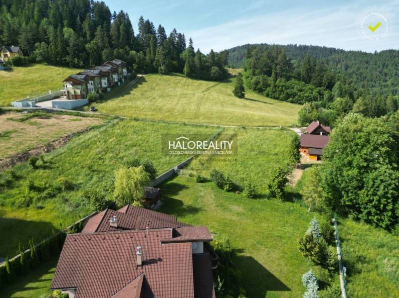 Freizeitgrundstücke in Vyšné Ružbachy, umgeben von Grünflächen und Wäldern am Hang eines Hügels.
